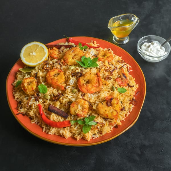 Shrimp biryani with lemon, chili, mint, and cinnamon, served with raita and ghee.